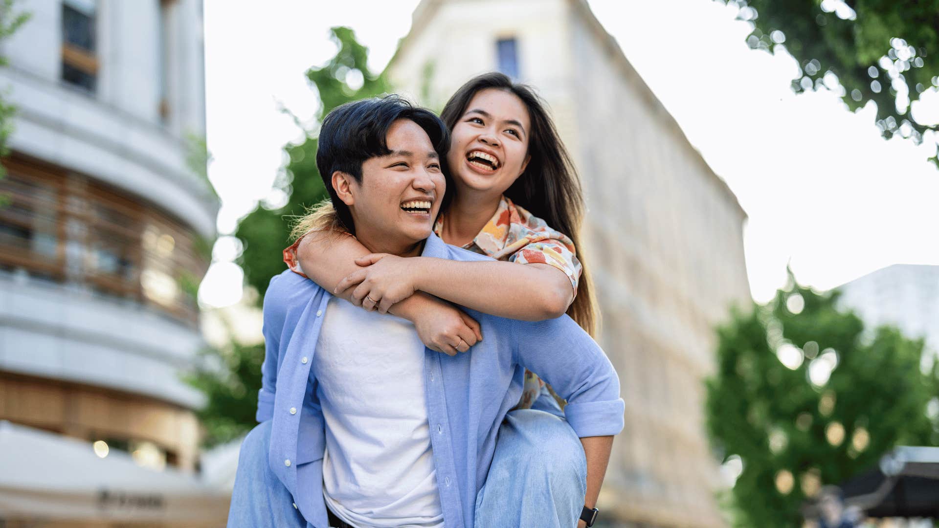 woman on man's back walking through city