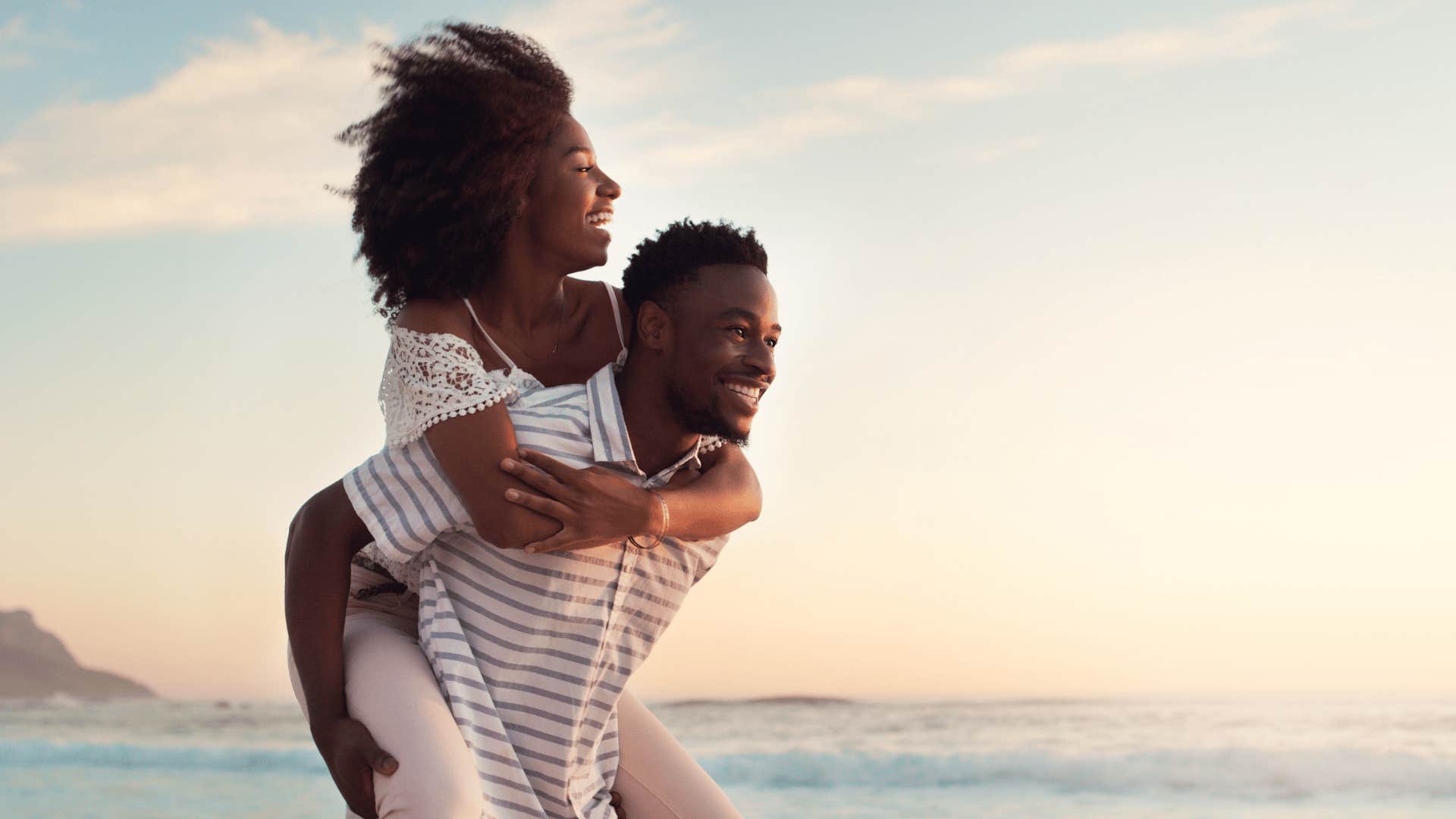 woman on man's back at beach