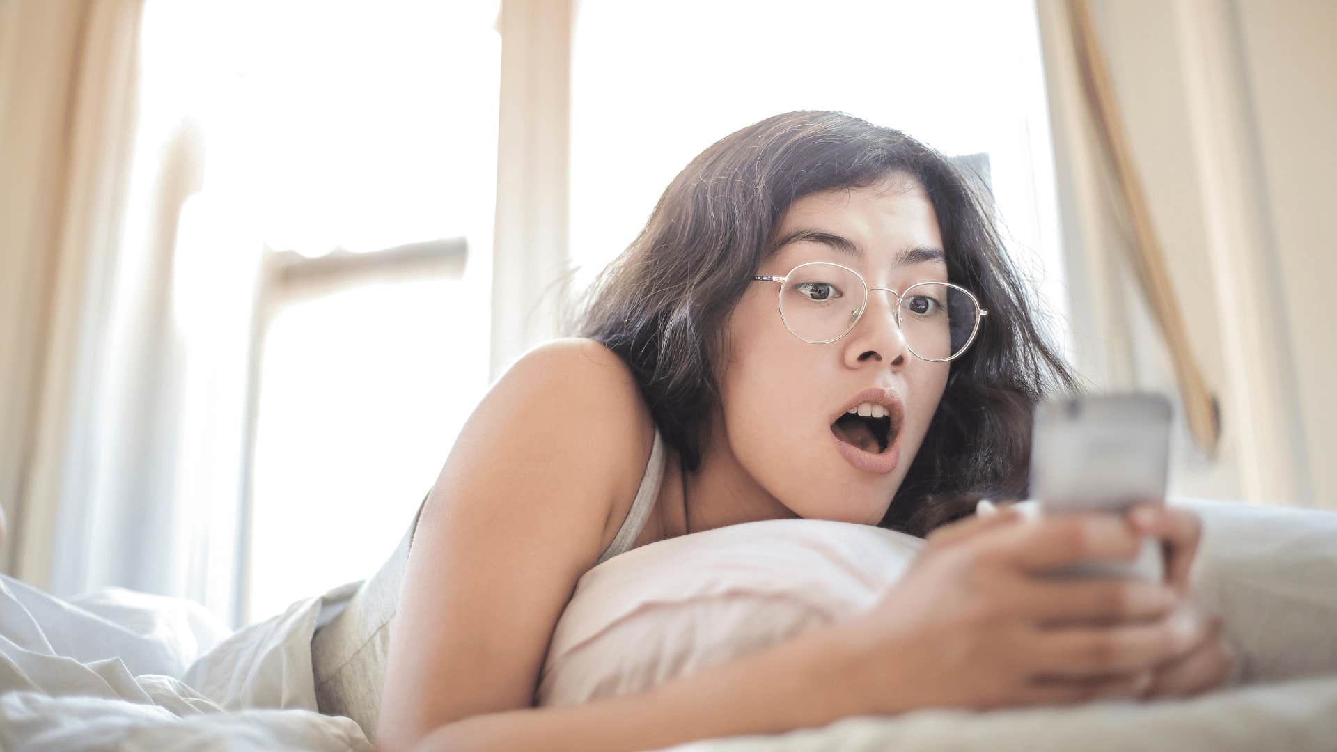 woman surprised looking at phone