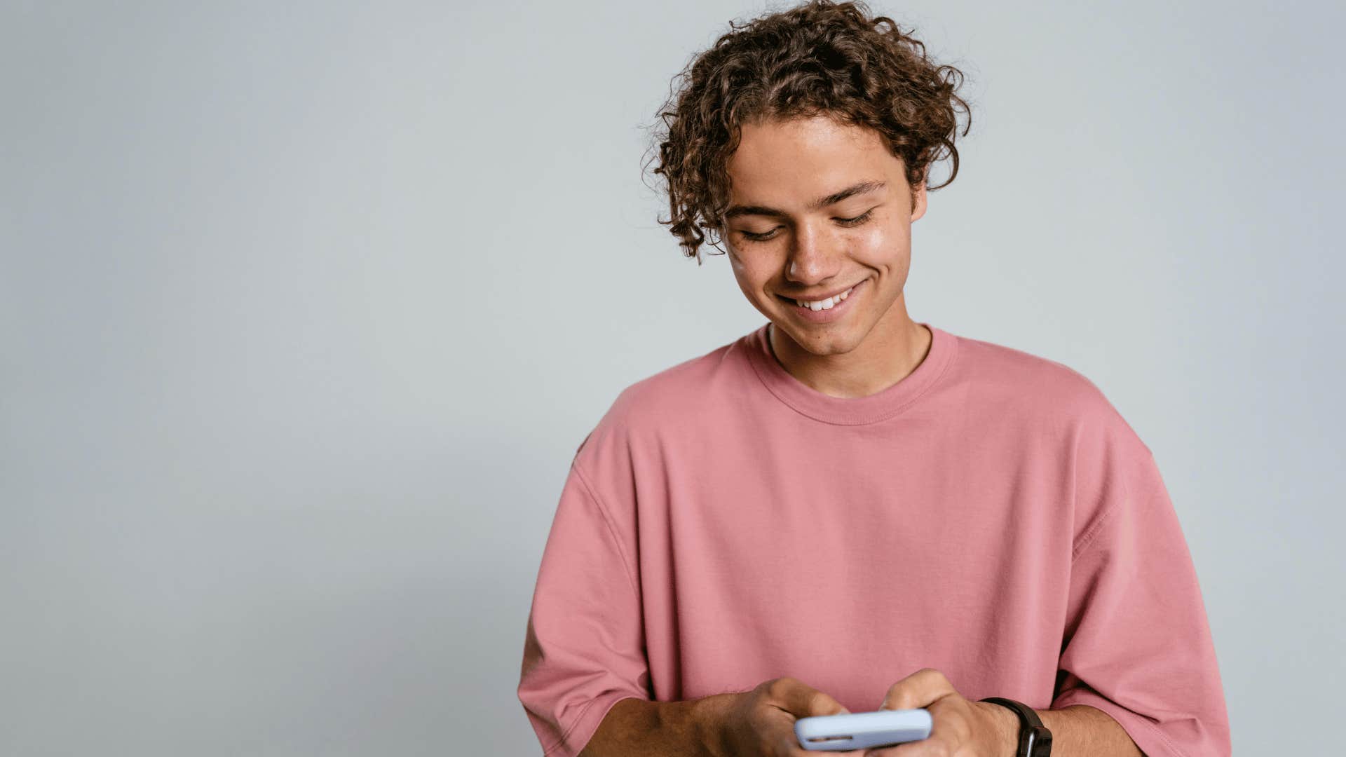 man smiling while texting