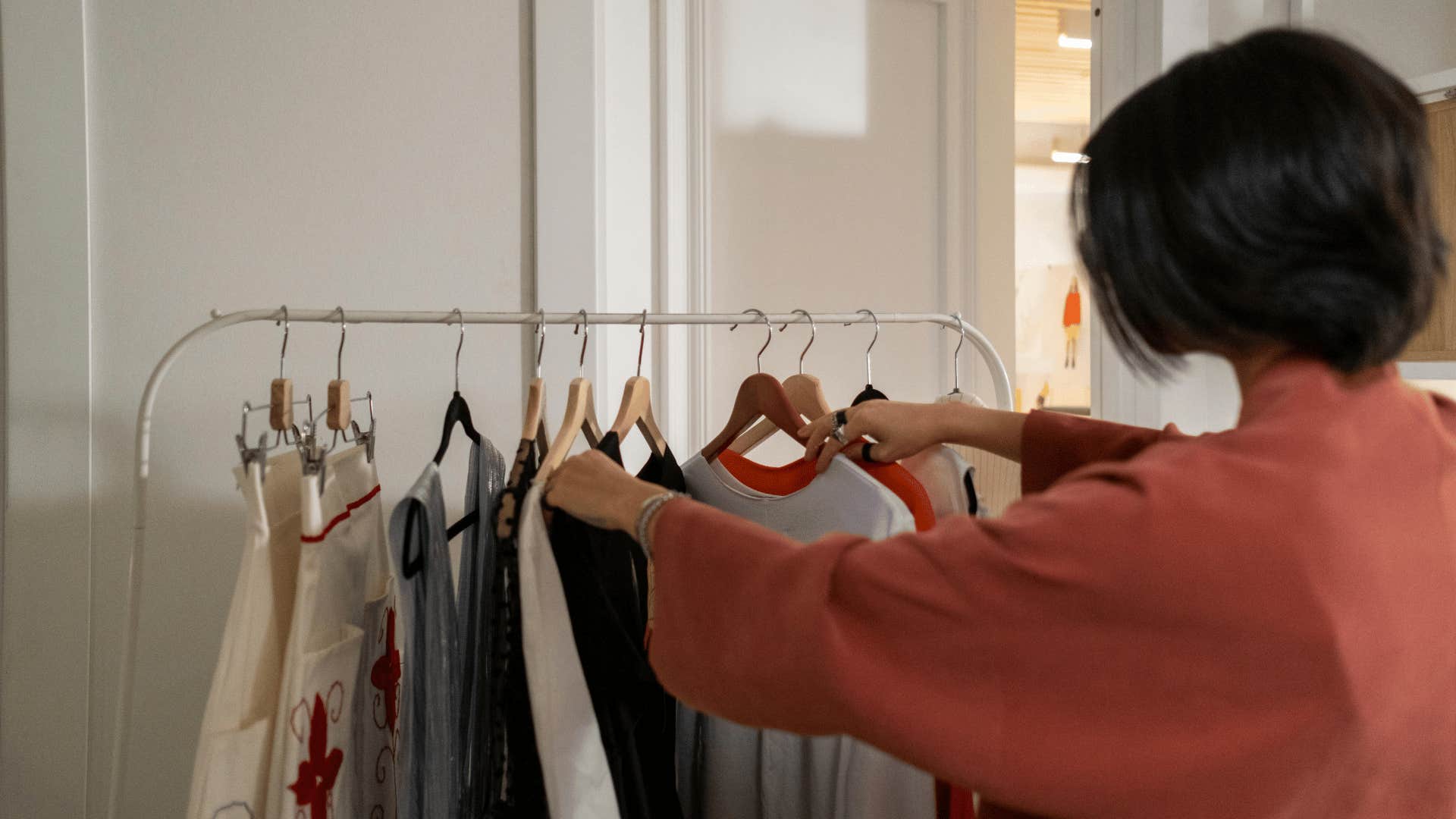 woman looking at clothes on rack