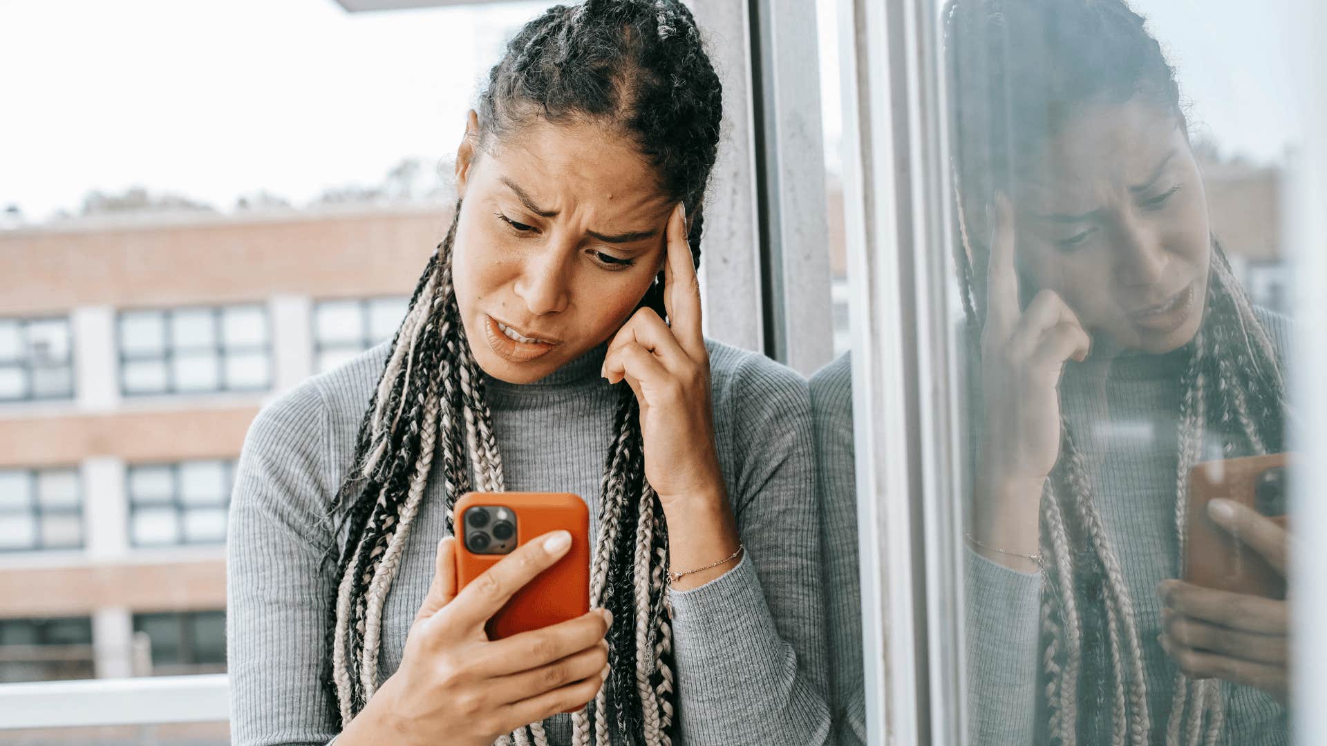 woman staring at phone upset