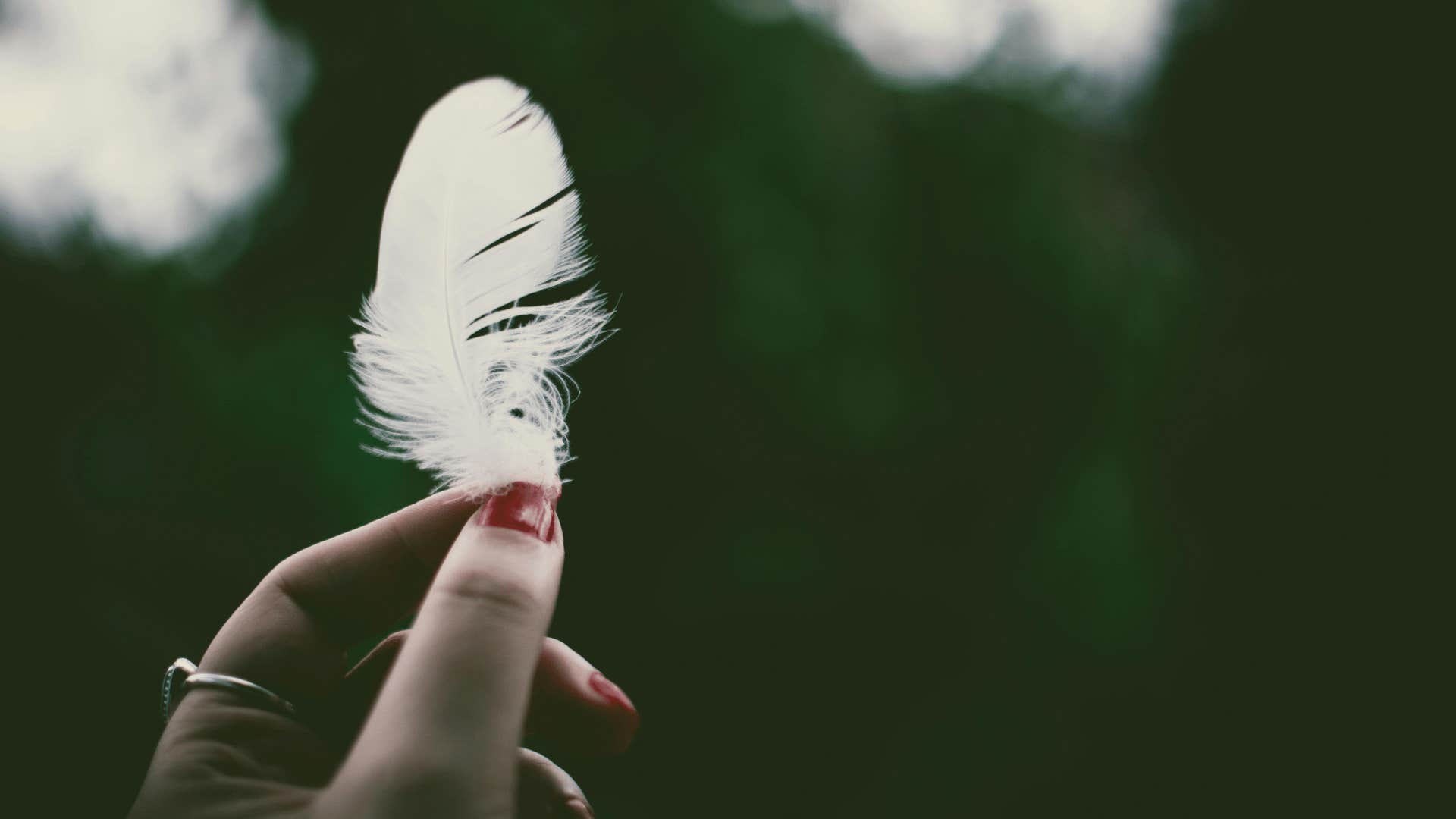 woman holding a feather