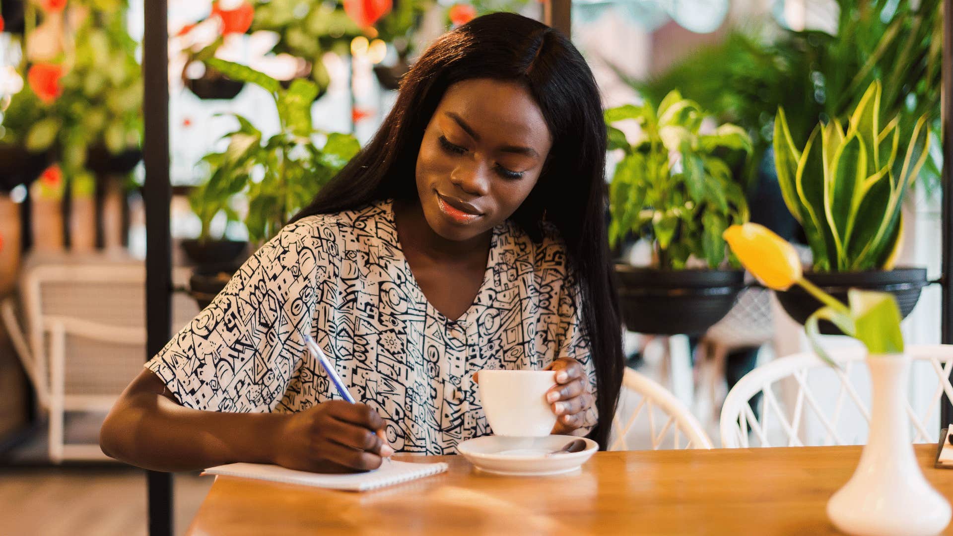 woman writing down stuff in journal 