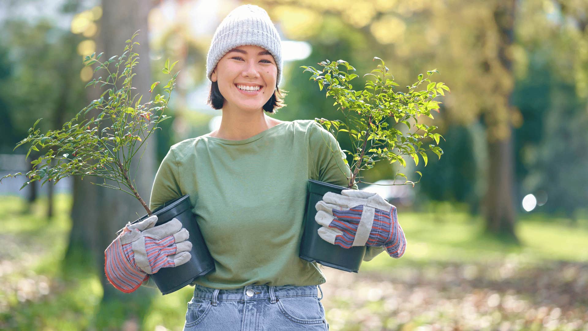 woman holding plants while smiling