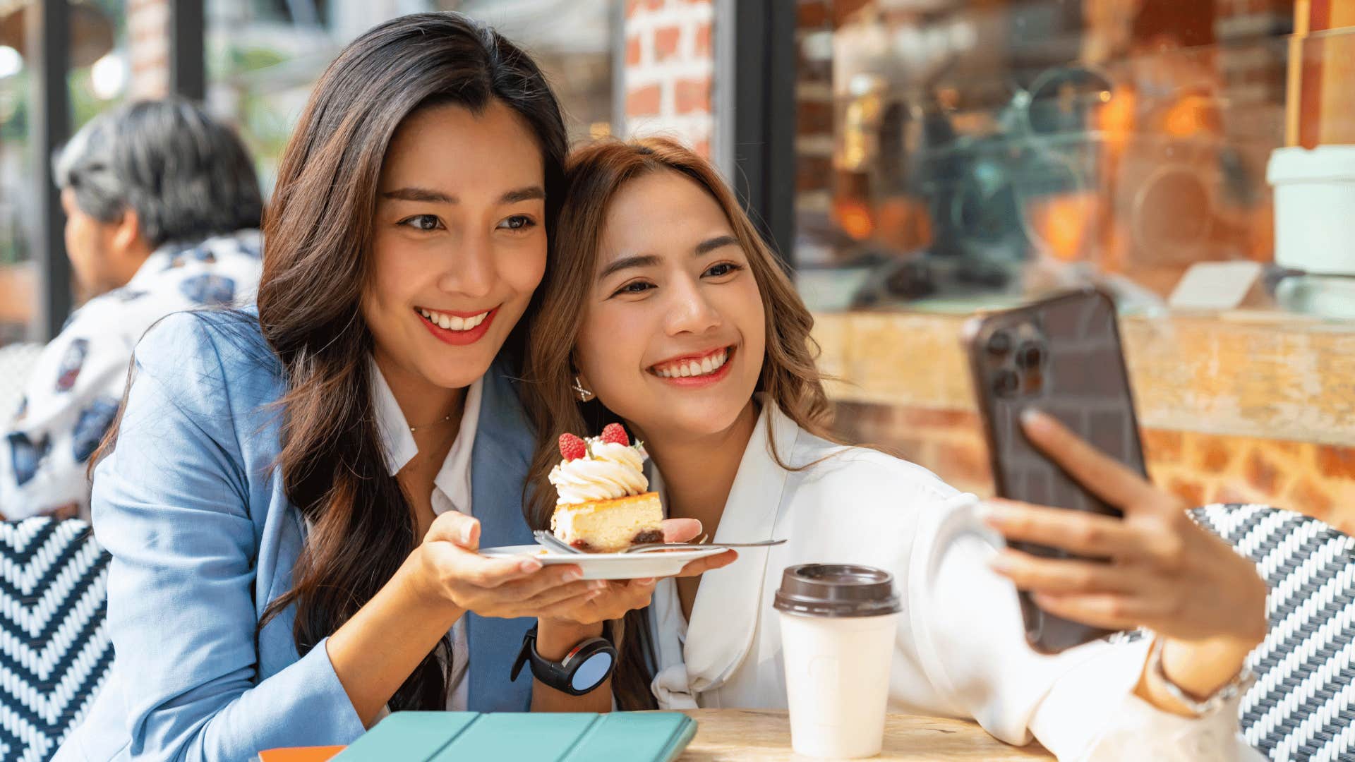 two friends taking a selfie while enjoying cafe