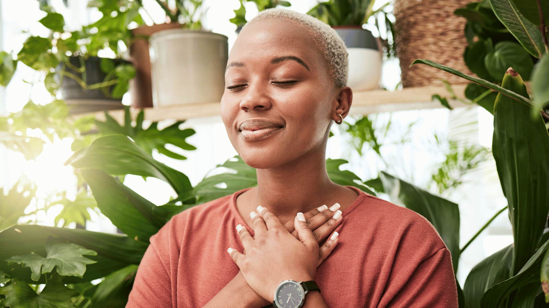 woman meditating while holding hand over heart