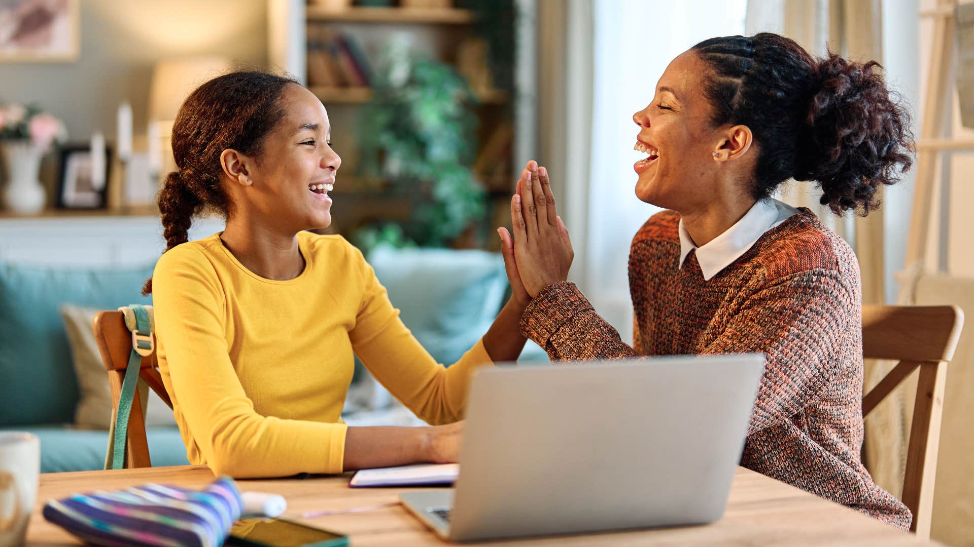 Mom high-fiving her teenage daughter