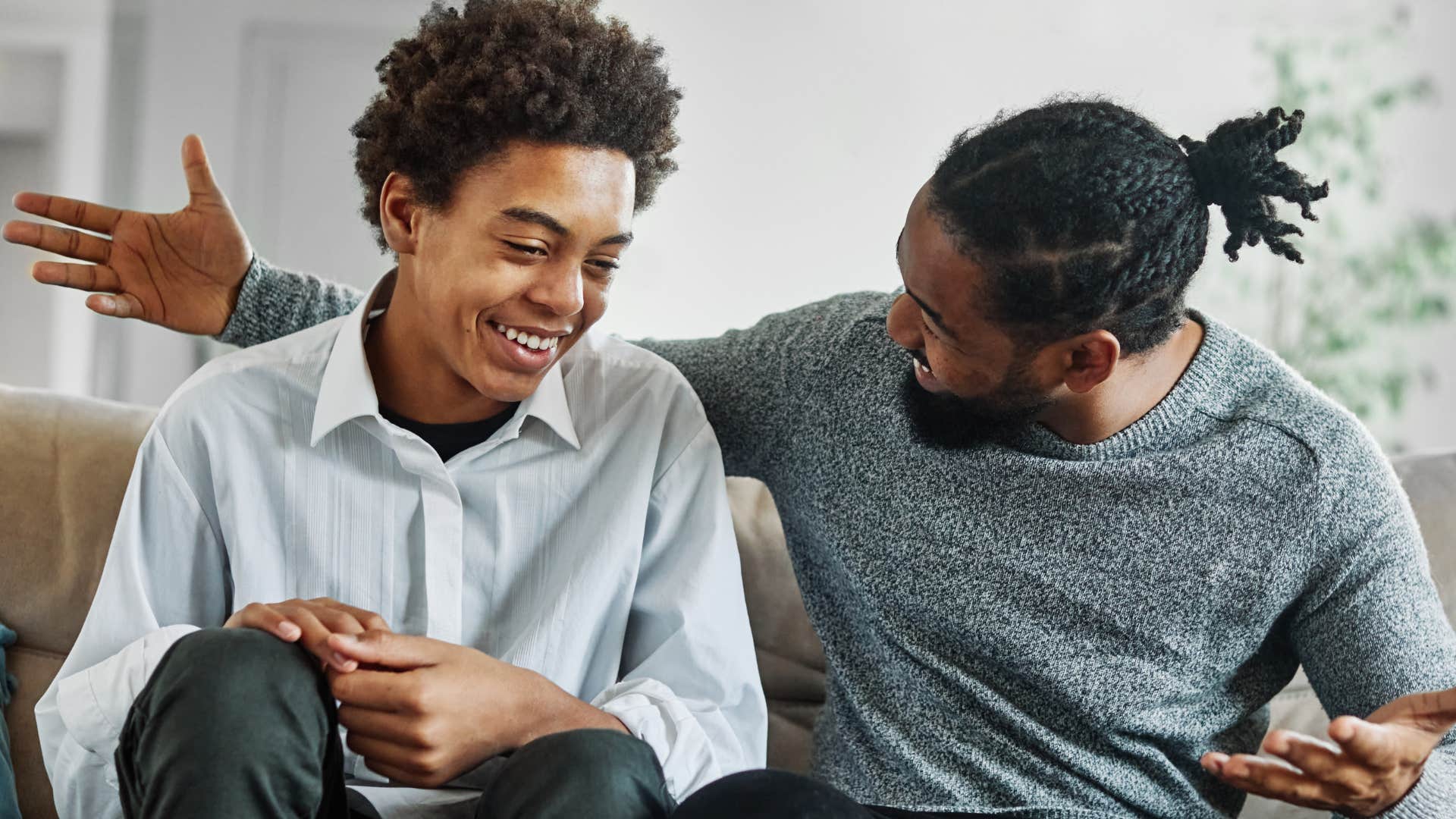 Young boy talking to his dad on the couch