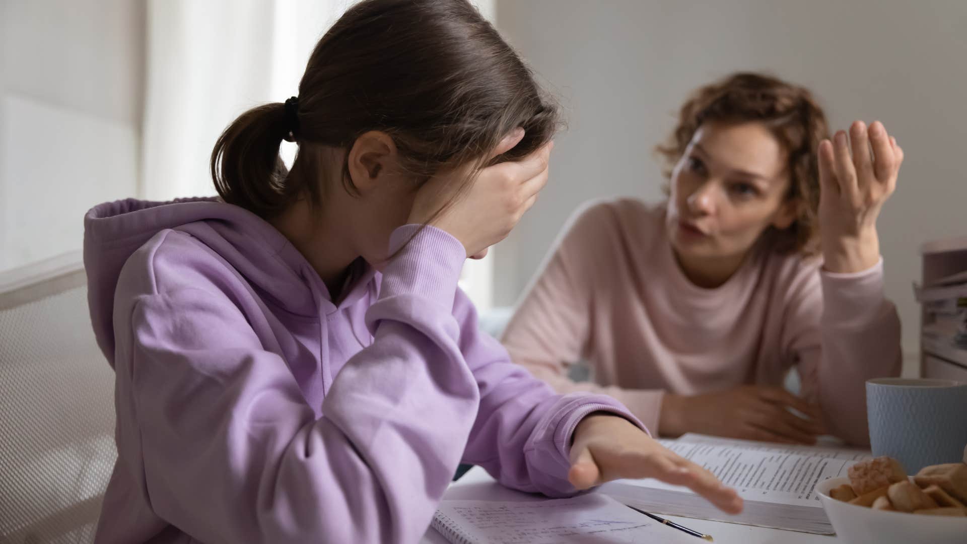 Woman talking to her upset teenage daughter