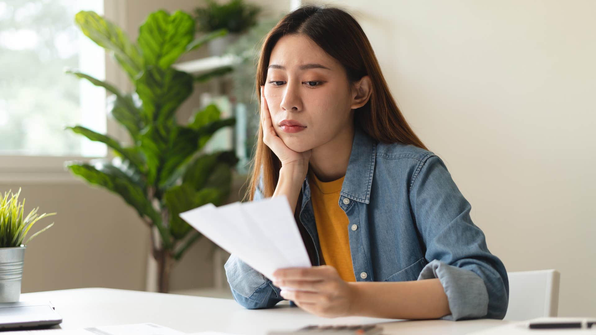 Woman looking upset staring at a paper