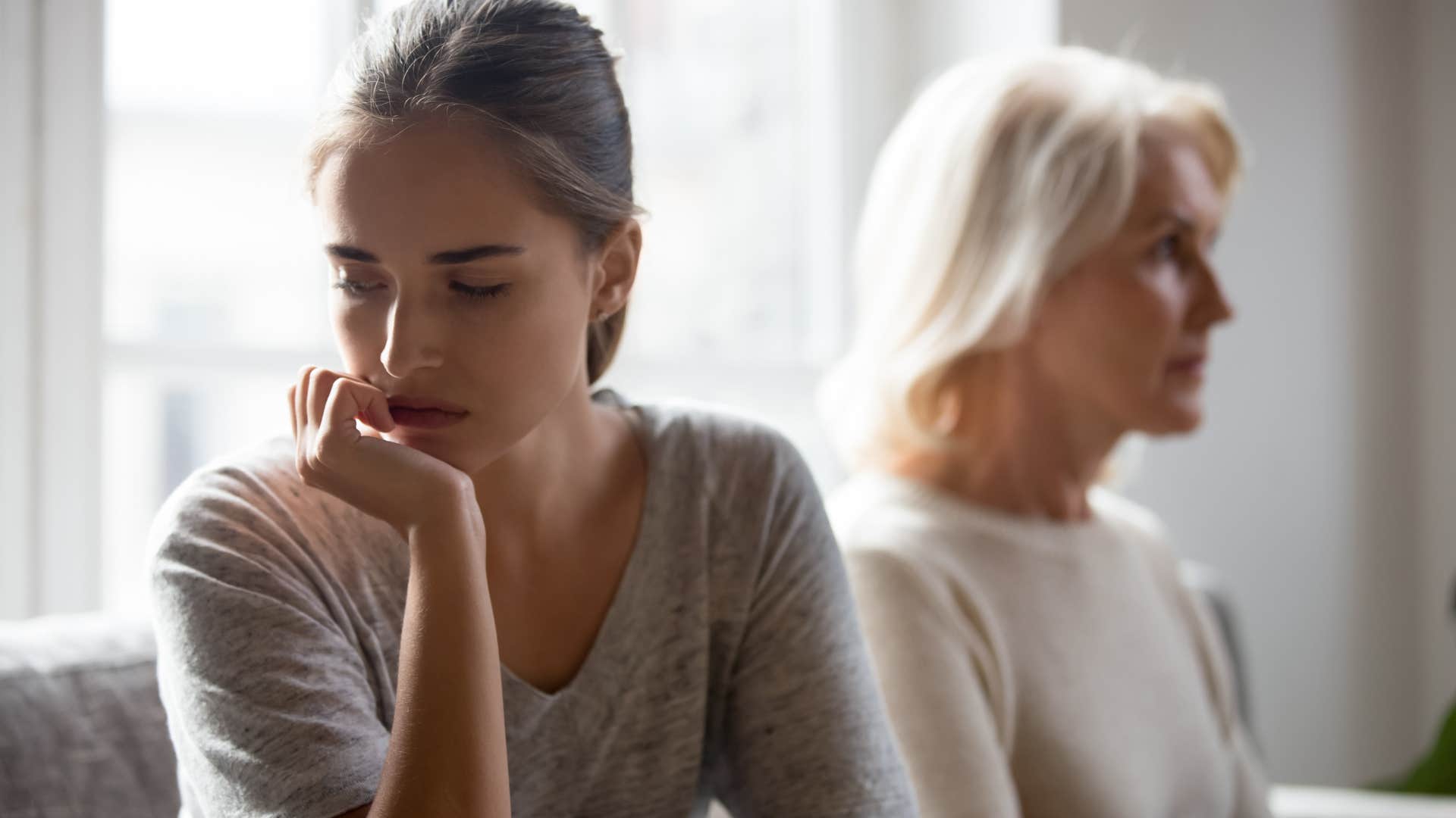 Adult woman turned away from her mother on the couch