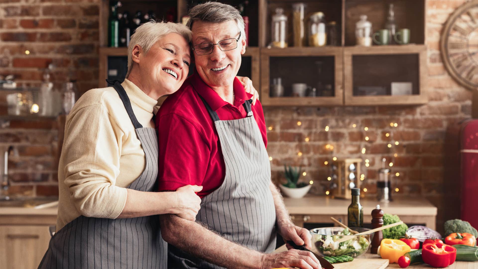 Couple smiling and cooking together in the kitchen