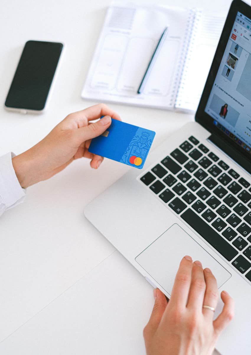 person holding credit card while shopping online