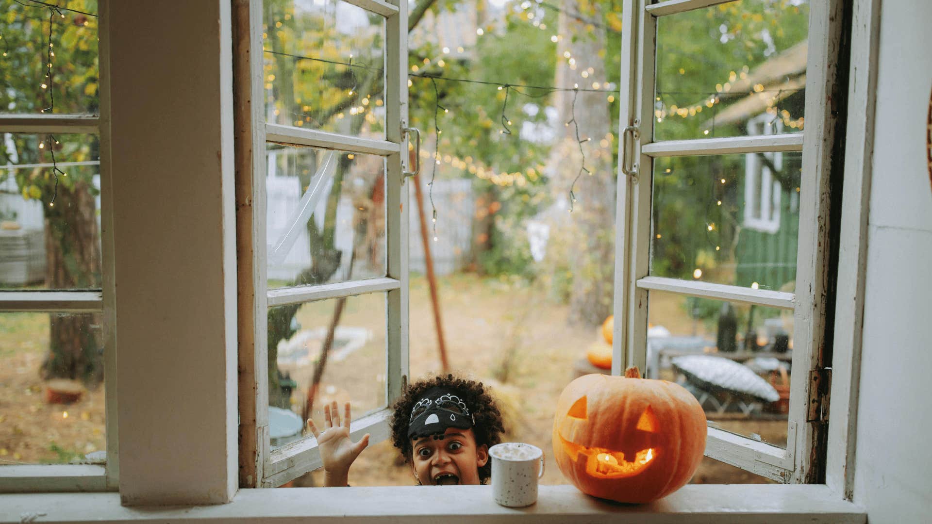 pumpkin on windowsill next to child