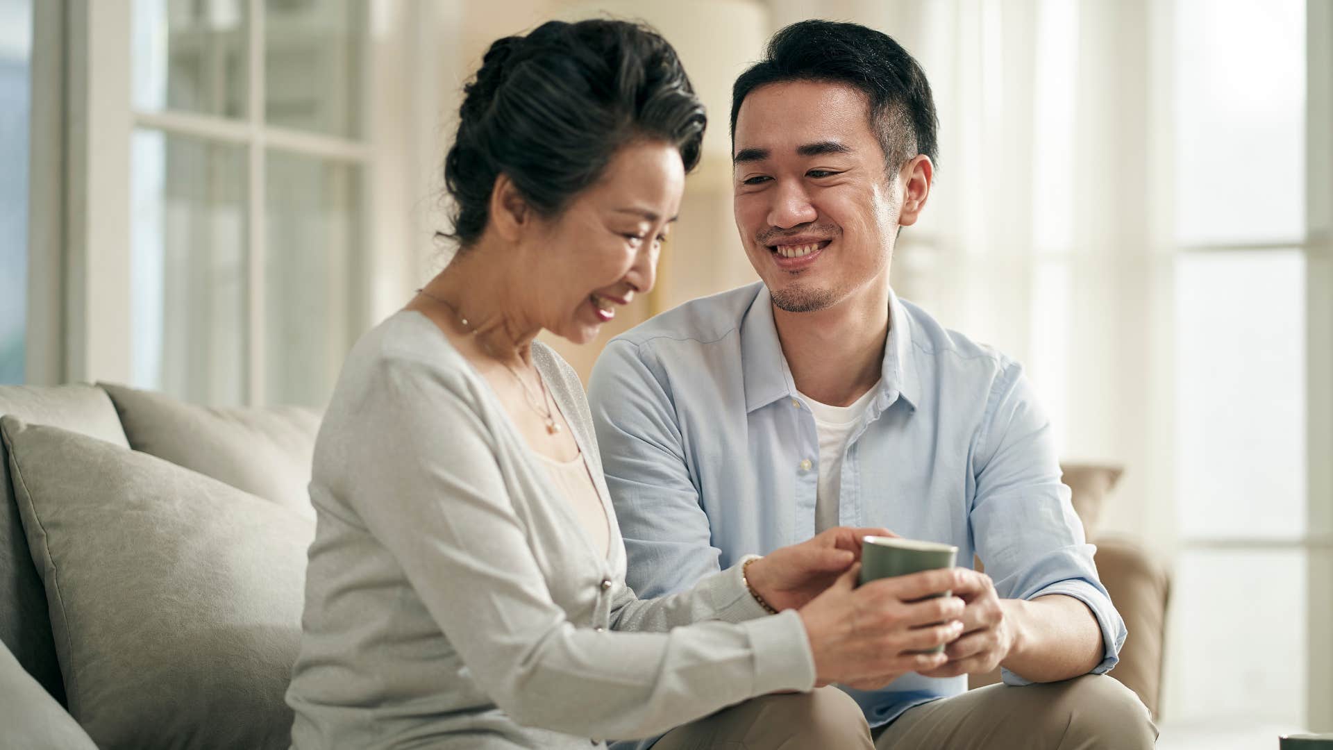 Mother smiling and talking to her adult son.