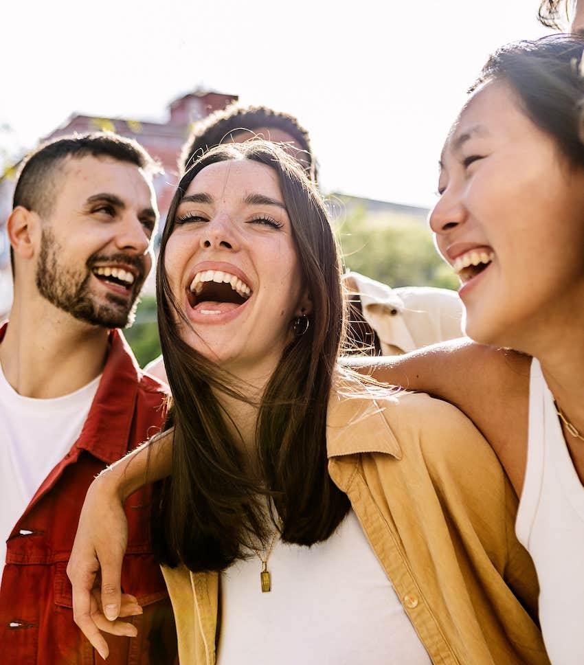 Passionate woman laughs and is loved by a group of friends