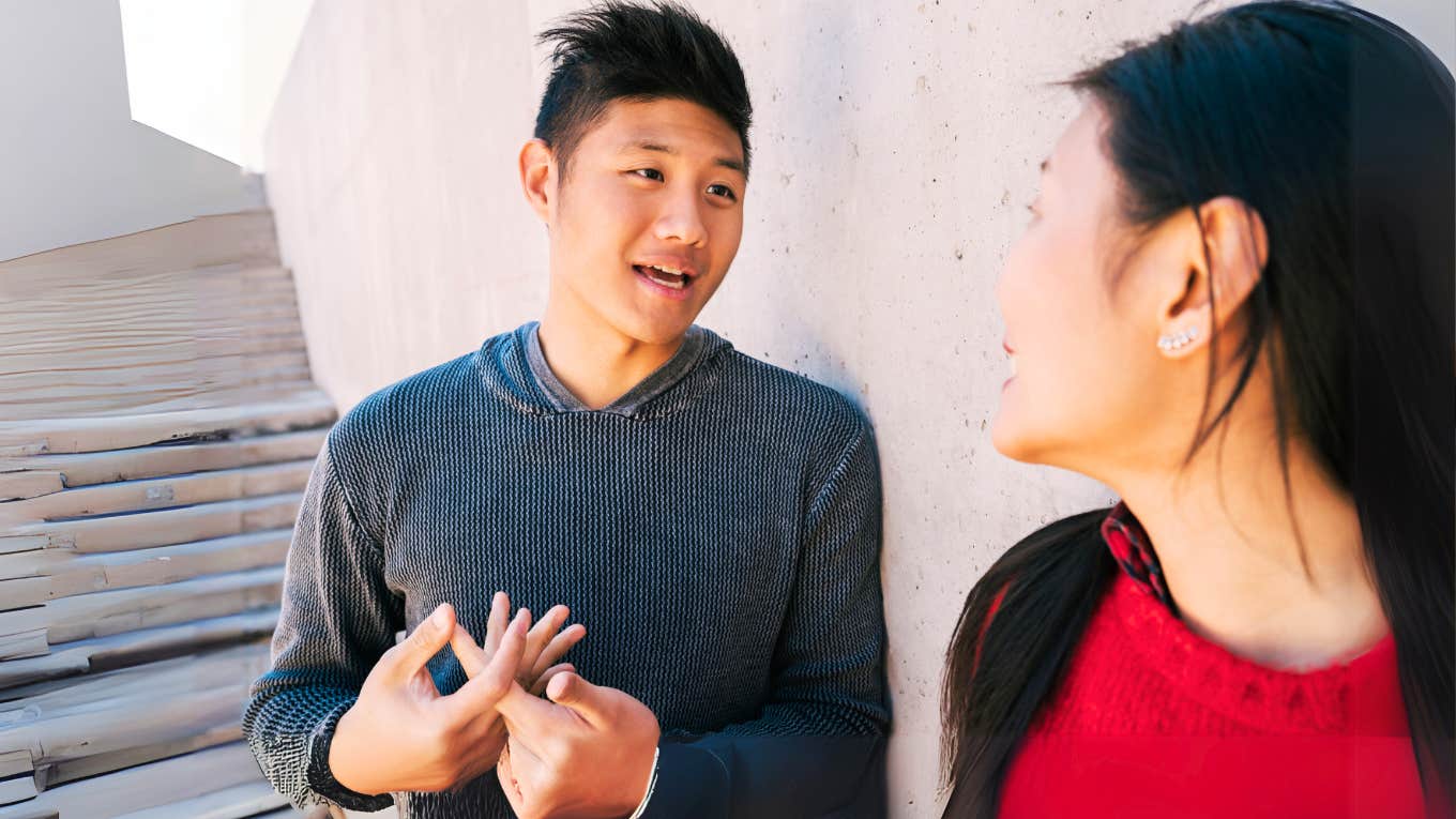 Man communicating with woman outside. 