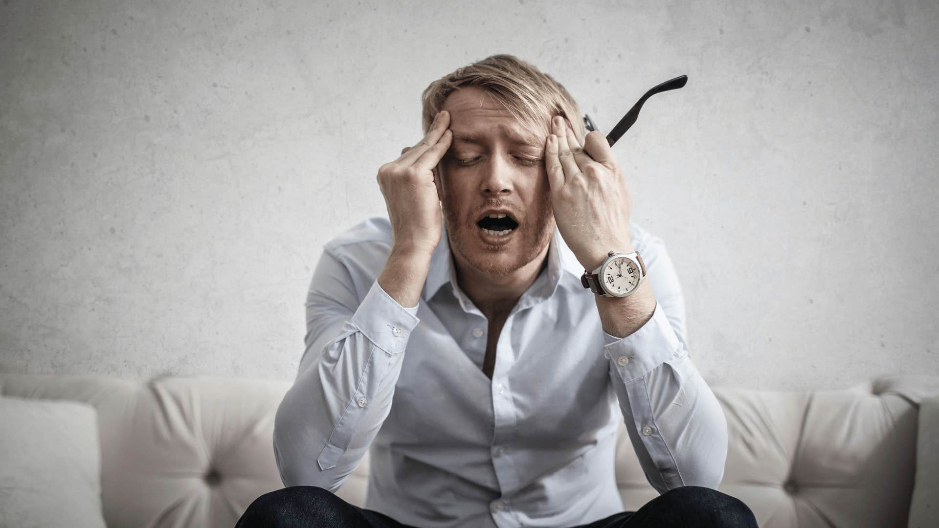 man holding head in hands