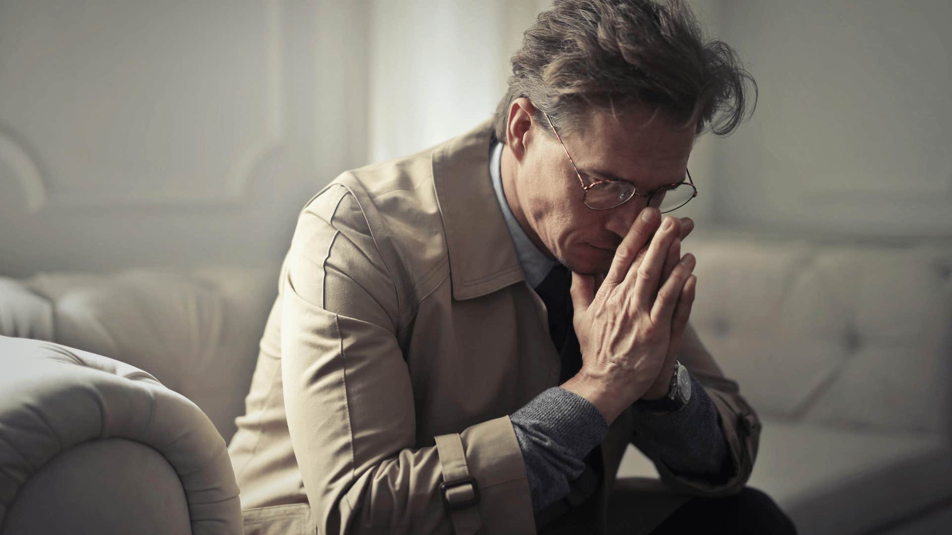 upset man sitting with his head in his hands