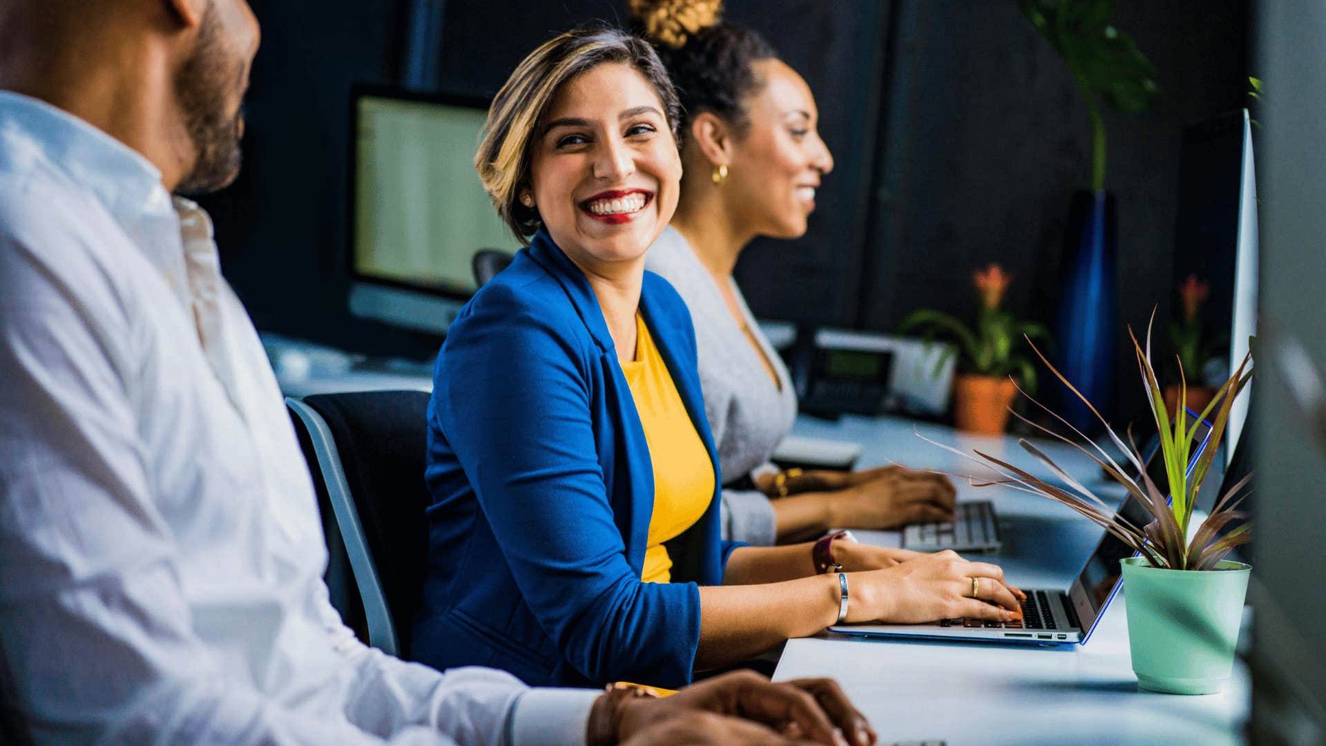 woman at computer smiling to man next to her