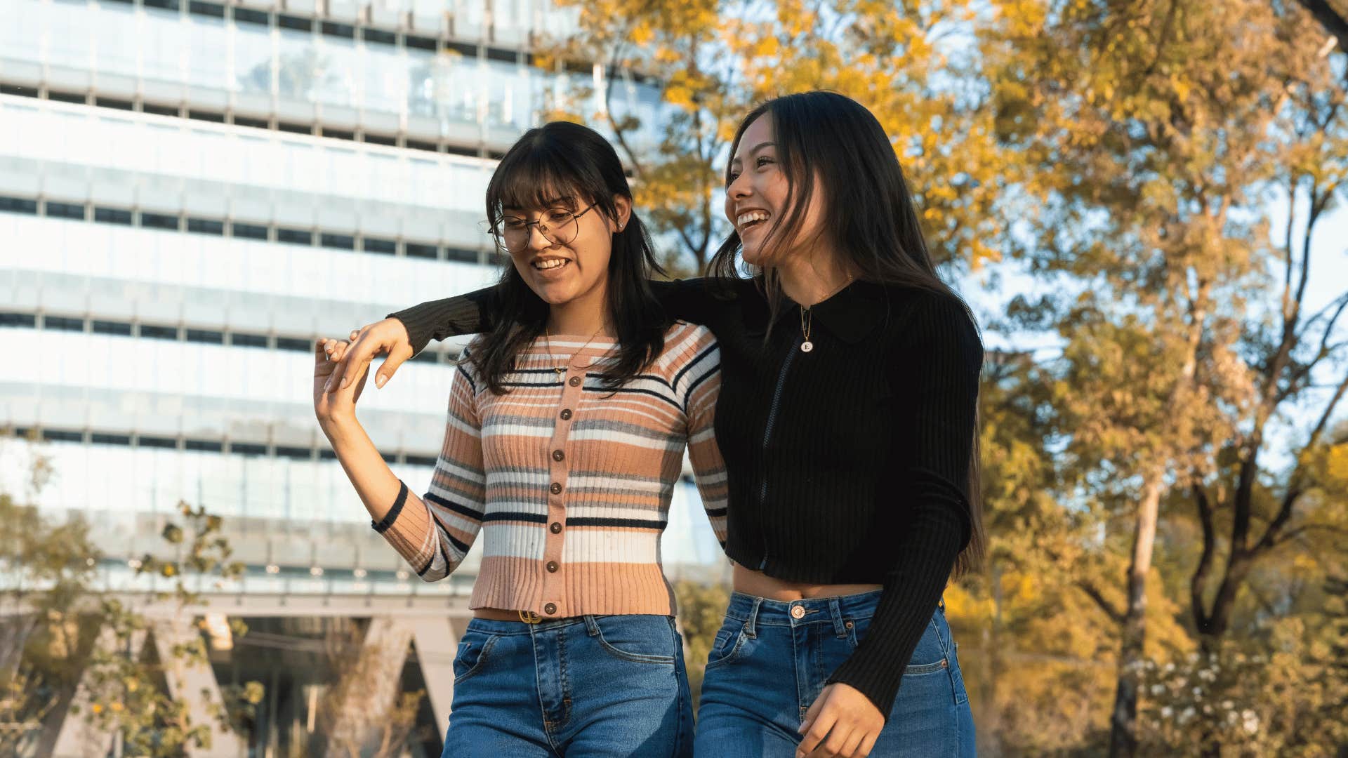 woman with her arm around friend in a park