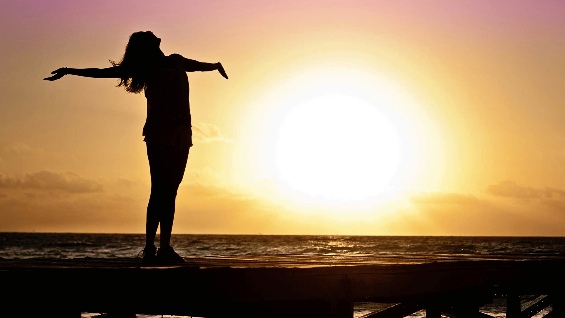 woman on beach with her hands in the air