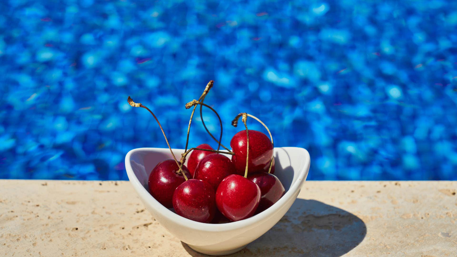 bowl of cherries next to the pool