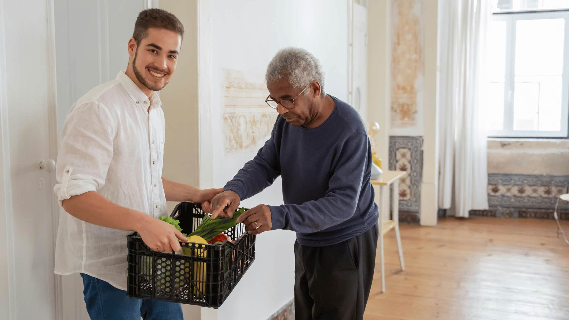 a man holding a plastic case helping older man