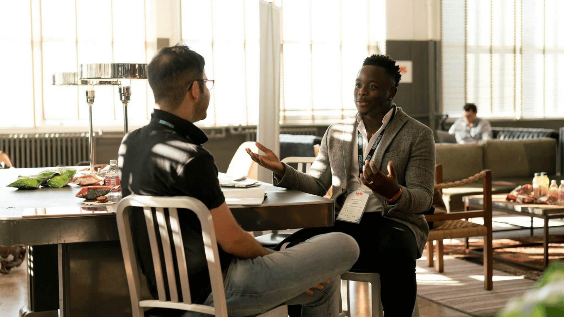 two men sitting across from each other and talking