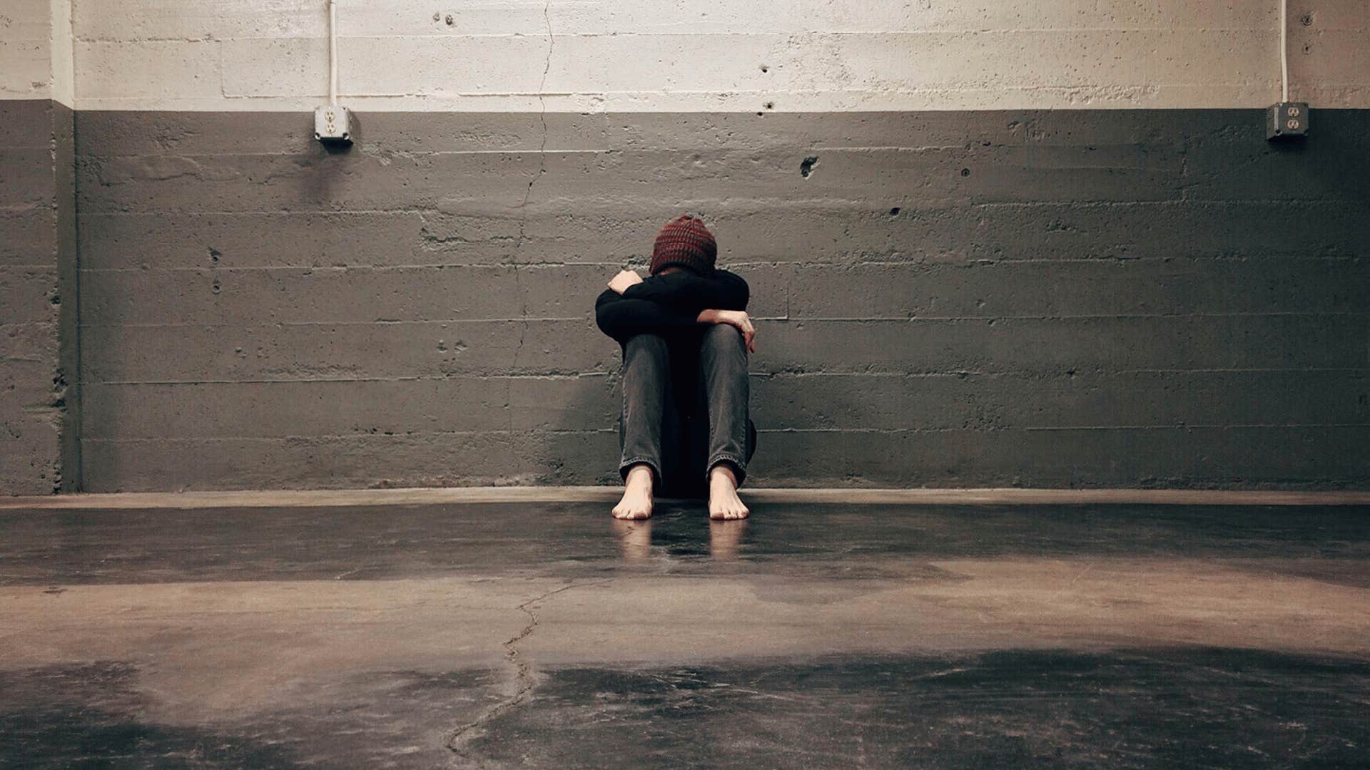 person sitting alone with their head in their hands