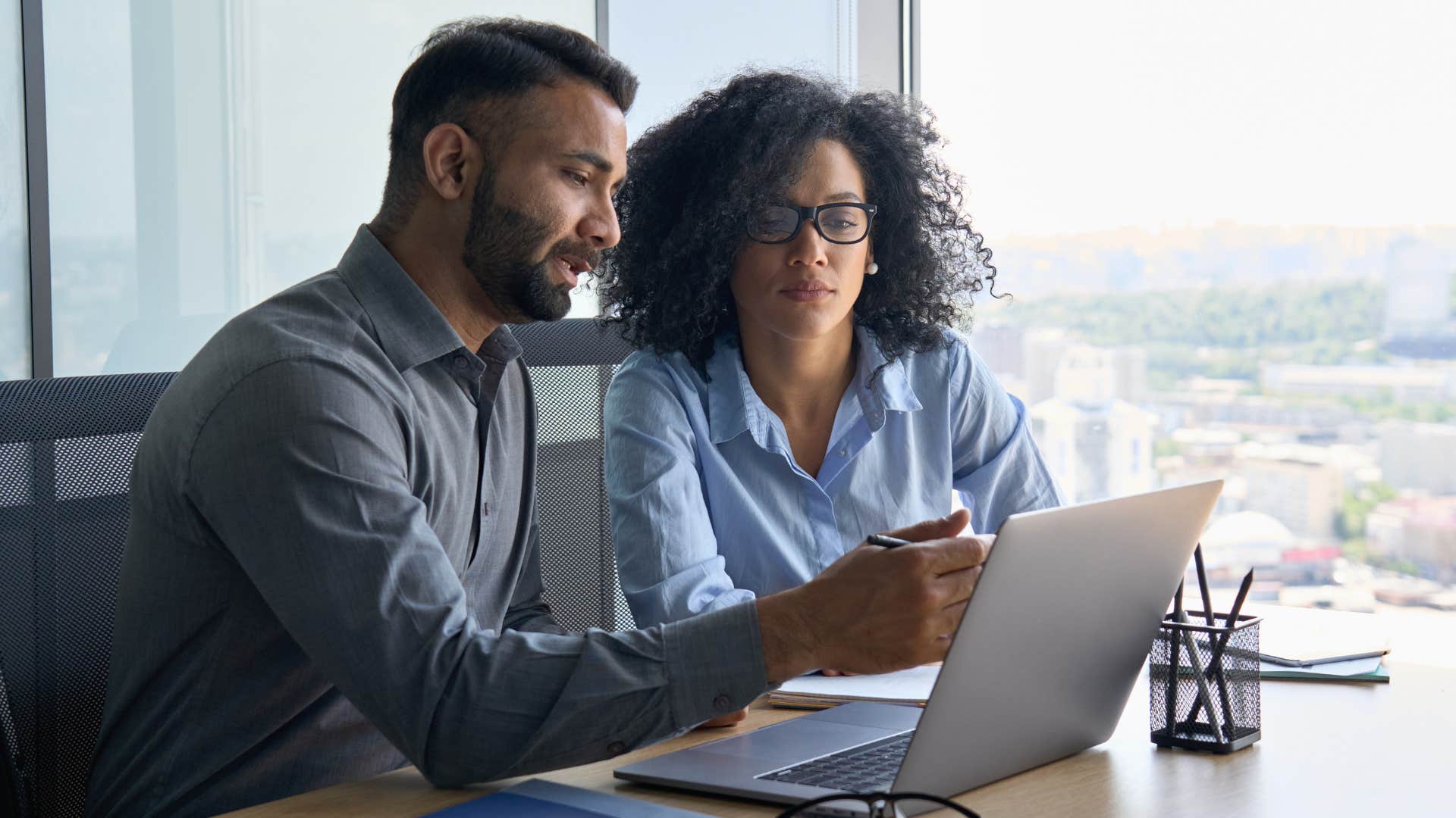 Man showing a woman something on his work computer.