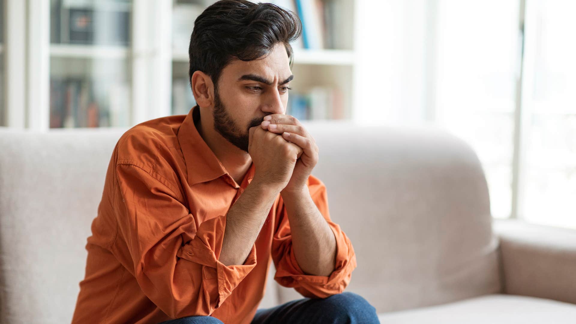 Man looking upset with his face in his hands.