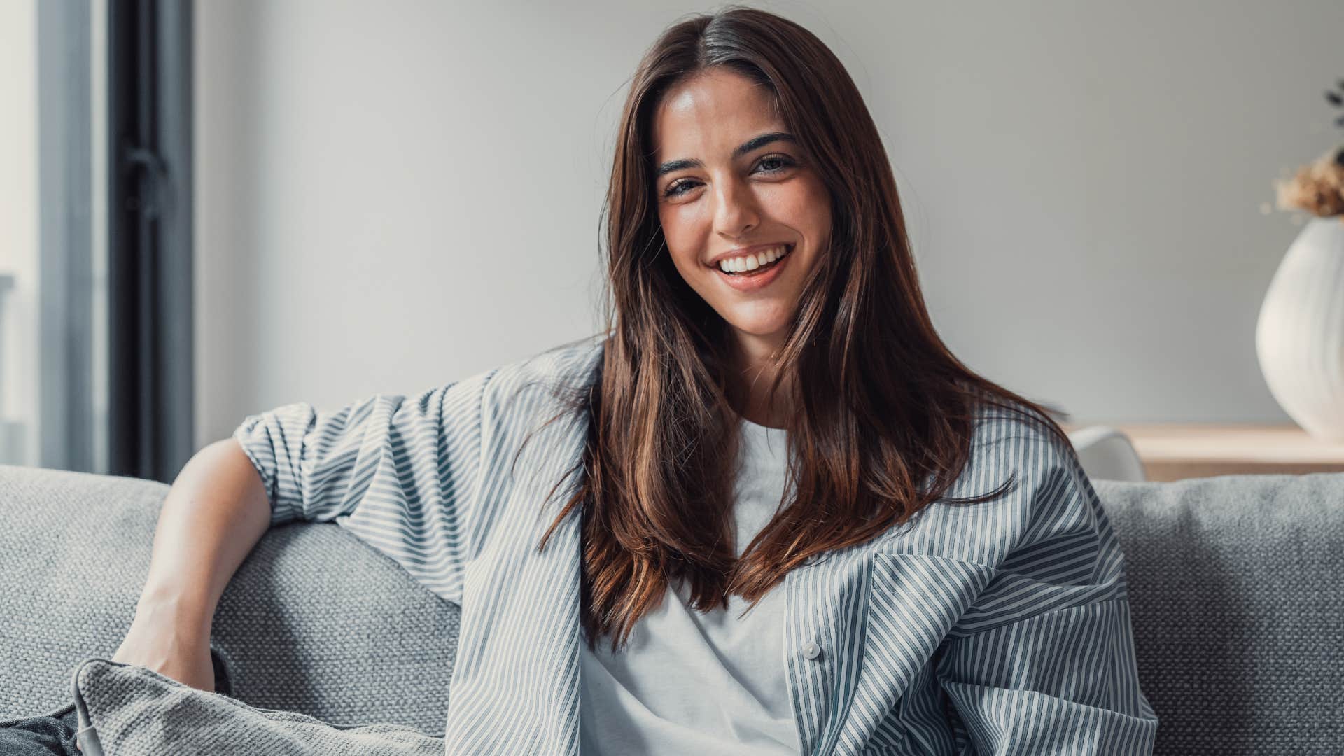 Woman smiling while sitting on the couch.