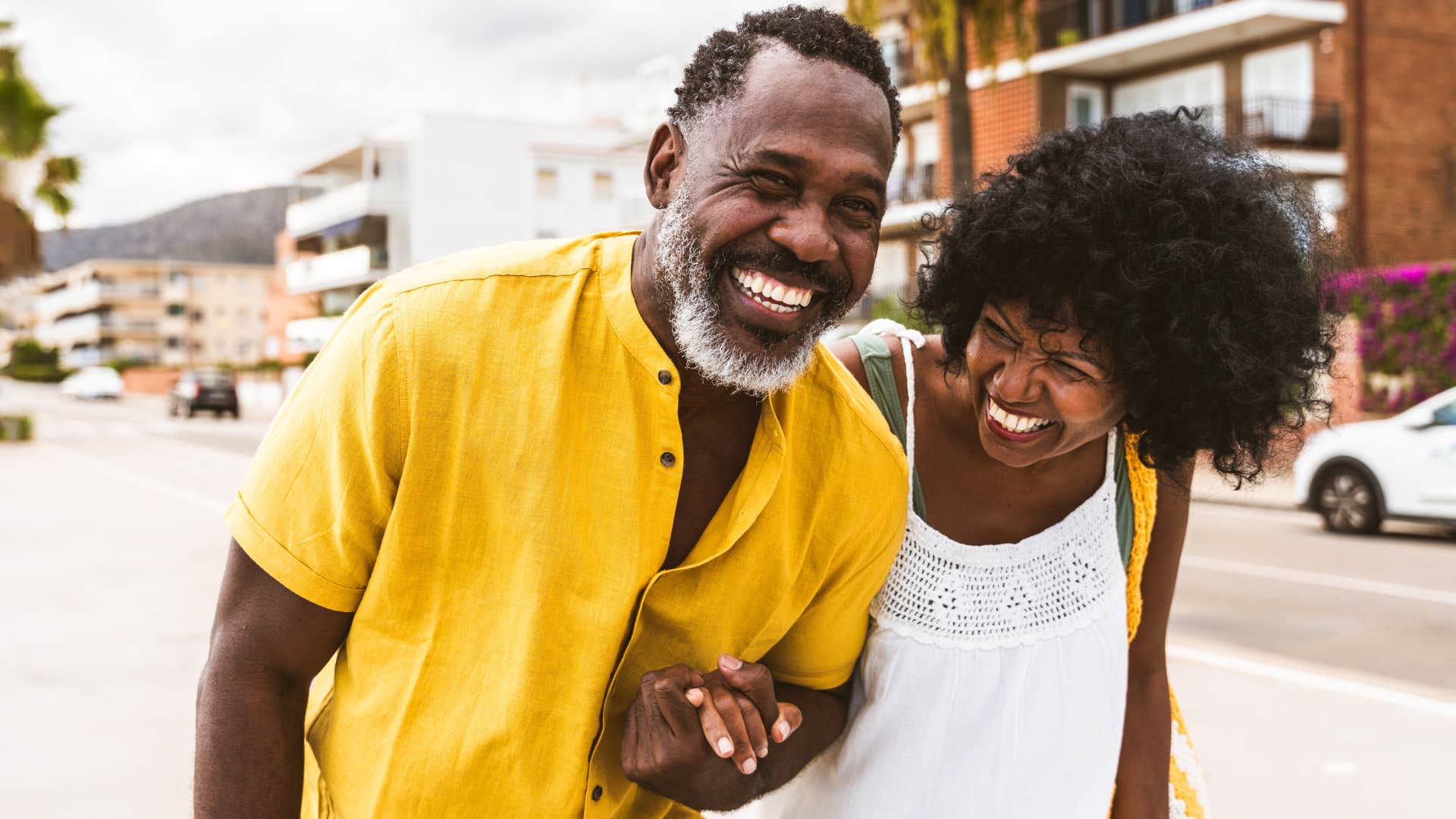 Man hugging a woman and smiling while walking with her.