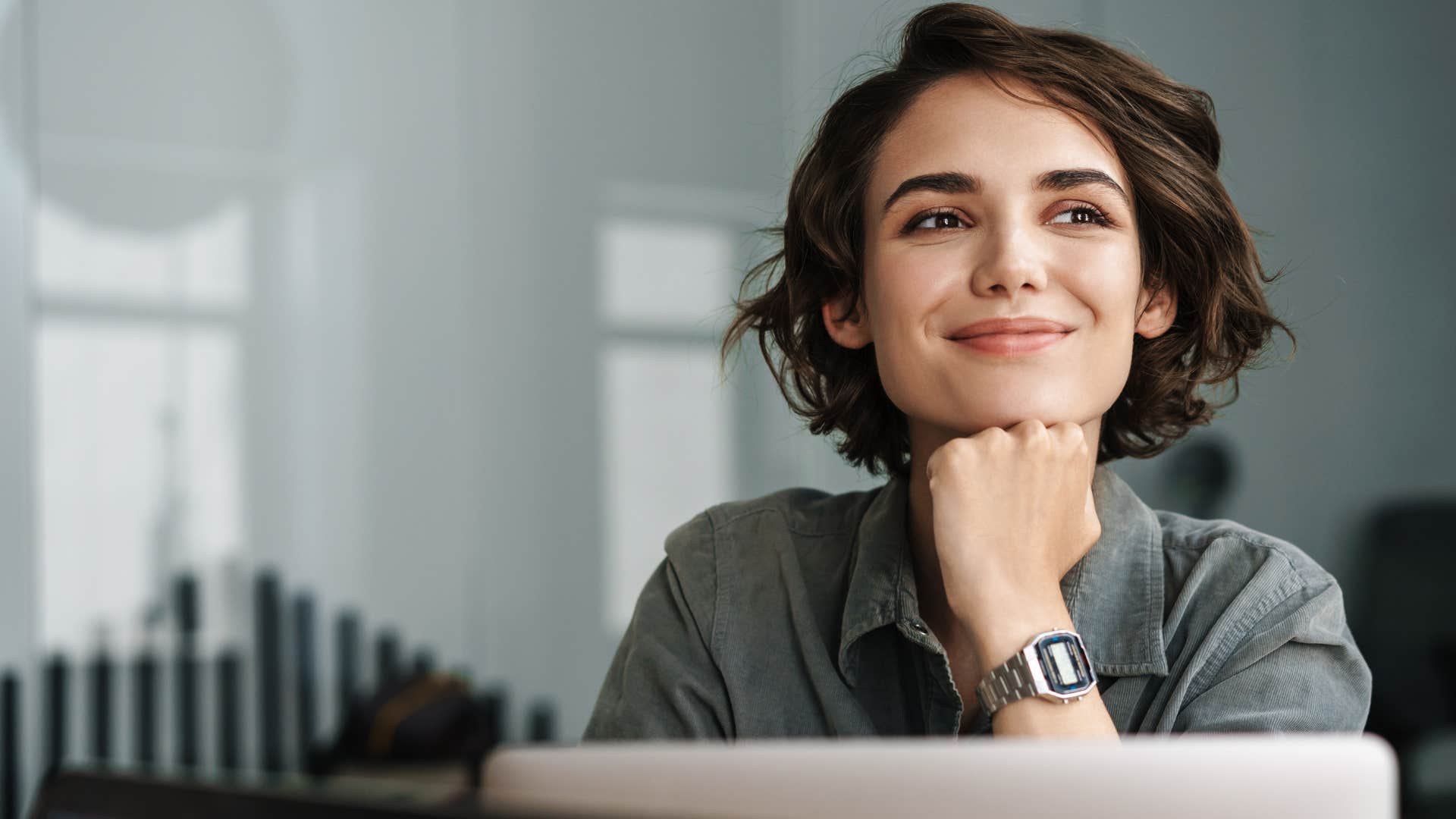 Woman smiling with her hand on her chin.