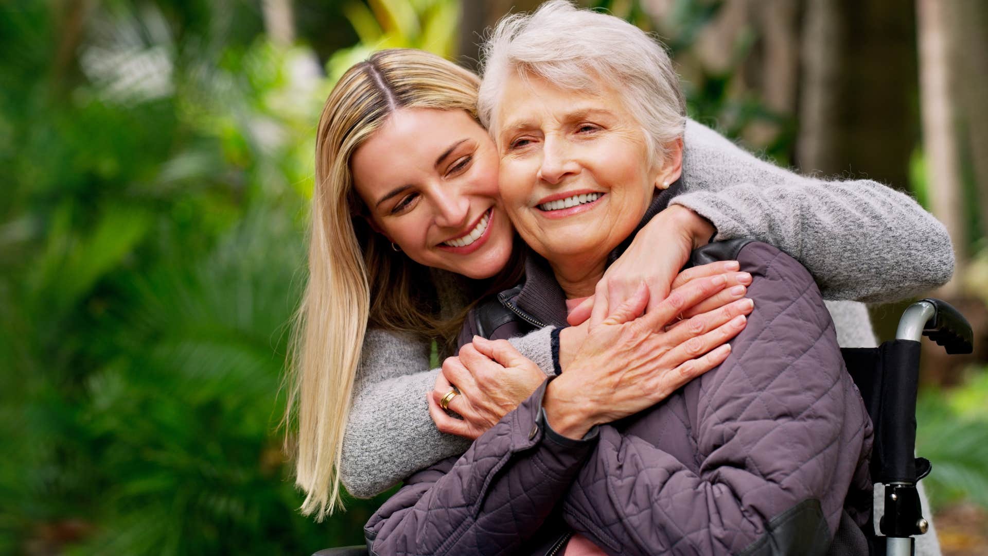 Woman hugging her older mother outside.