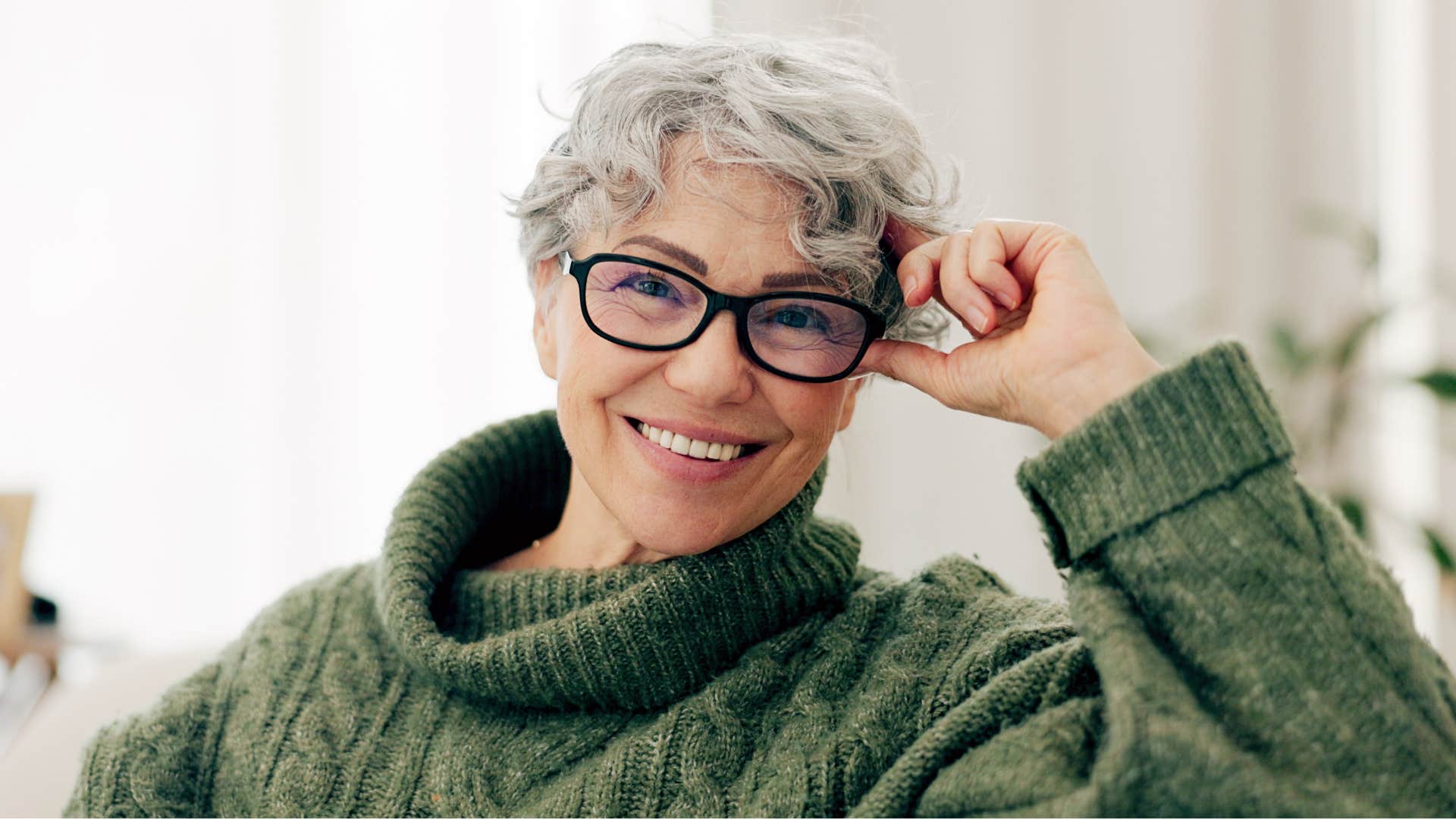 Older woman with glasses smiling.