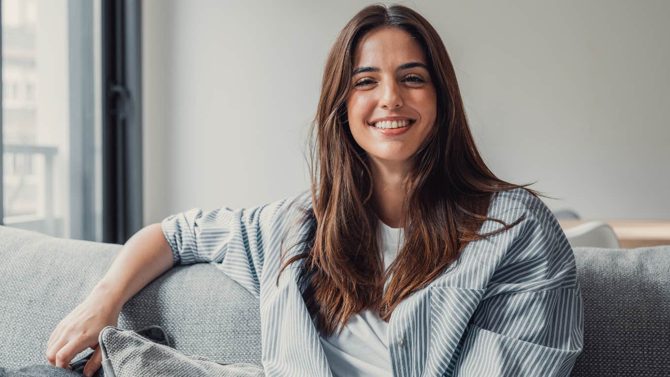 Woman smiling and sitting on her couch