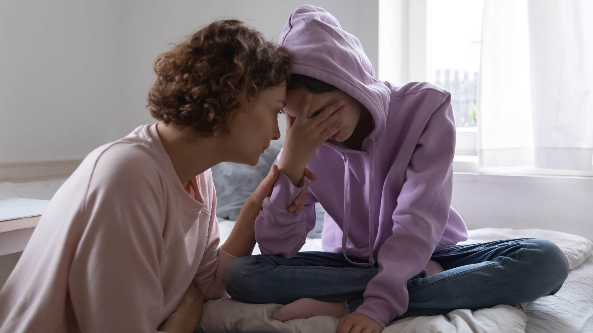 Mother comforting her upset teenage daughter.