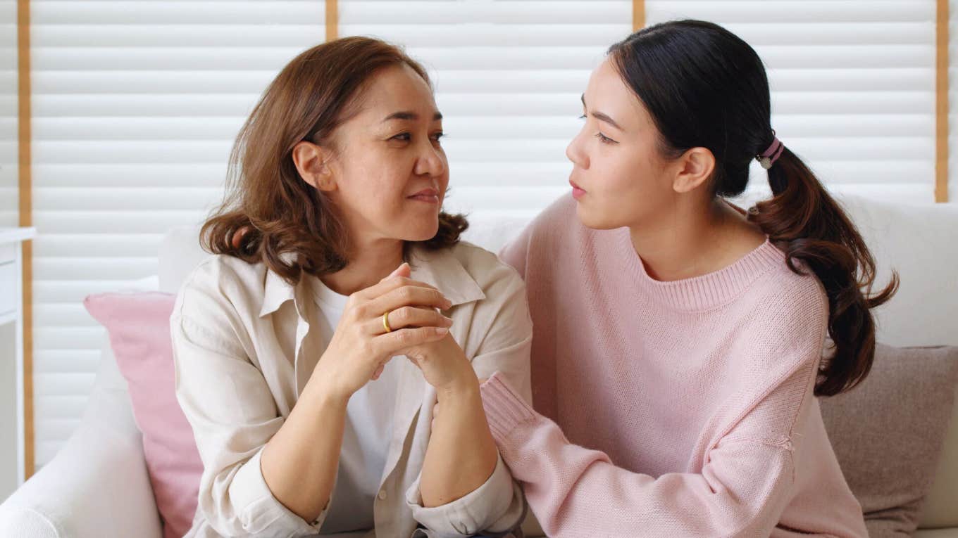 young woman talking to mother on couch