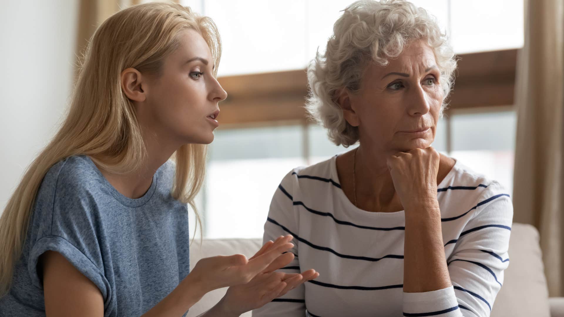 Woman looking annoyed while her young daughter talks to her