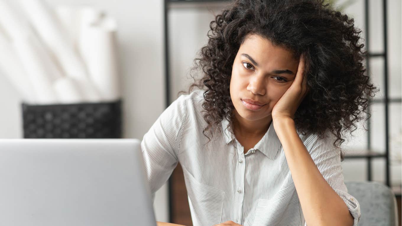 Woman looking annoyed sitting at her desk at work