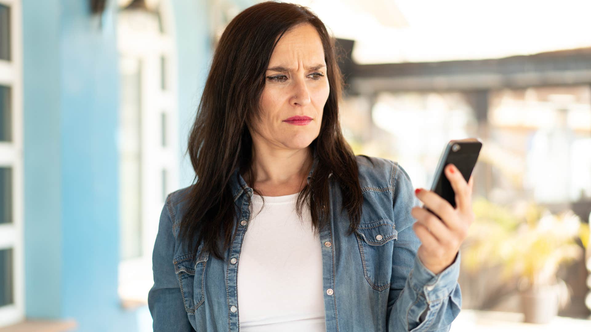 Woman looking annoyed staring at her phone