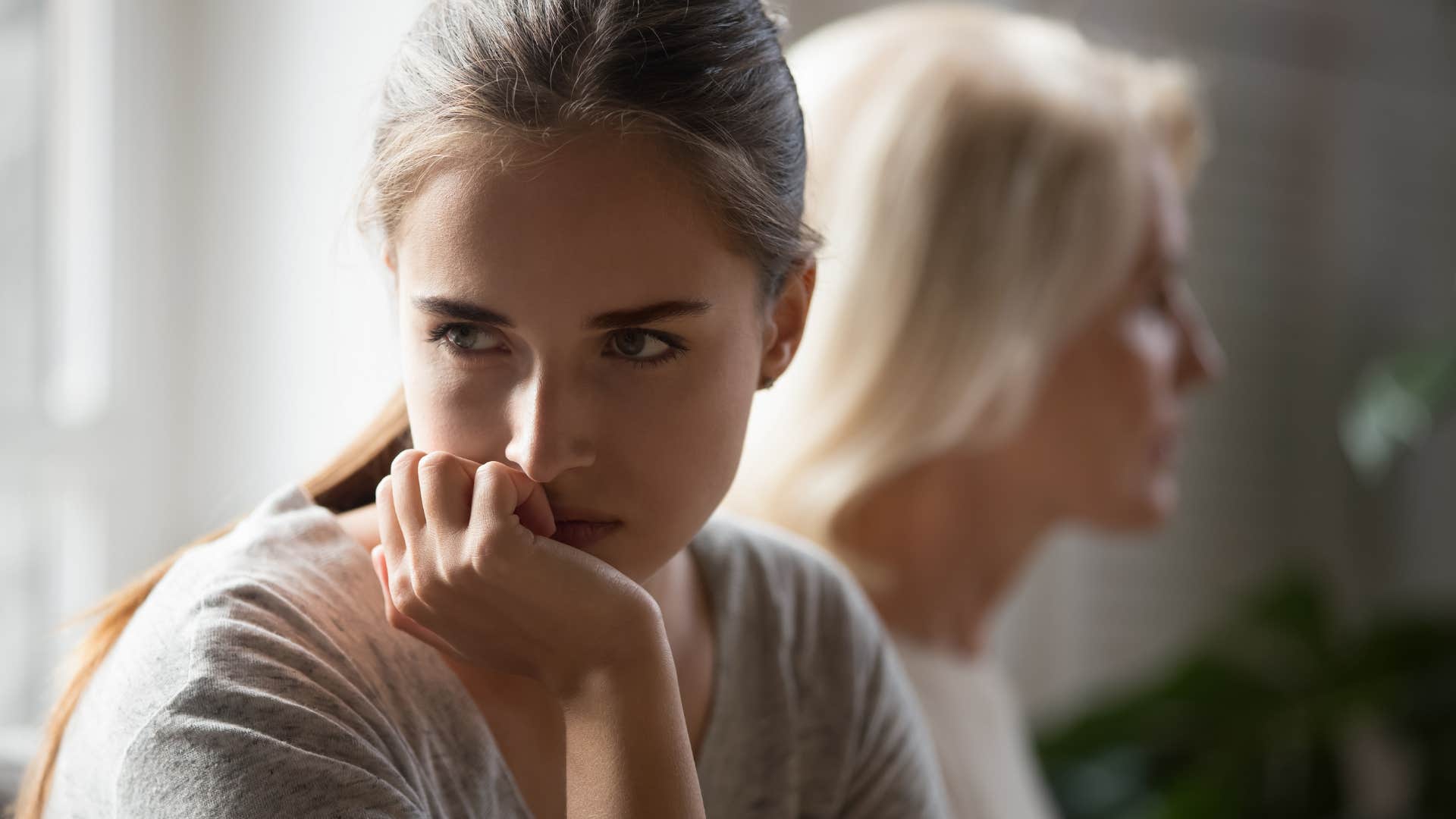 Adult daughter looking upset turned away from her mother.