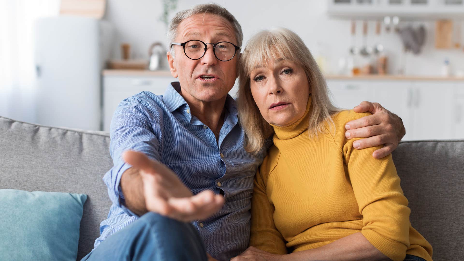 Older couple looking annoyed arguing to the camera.