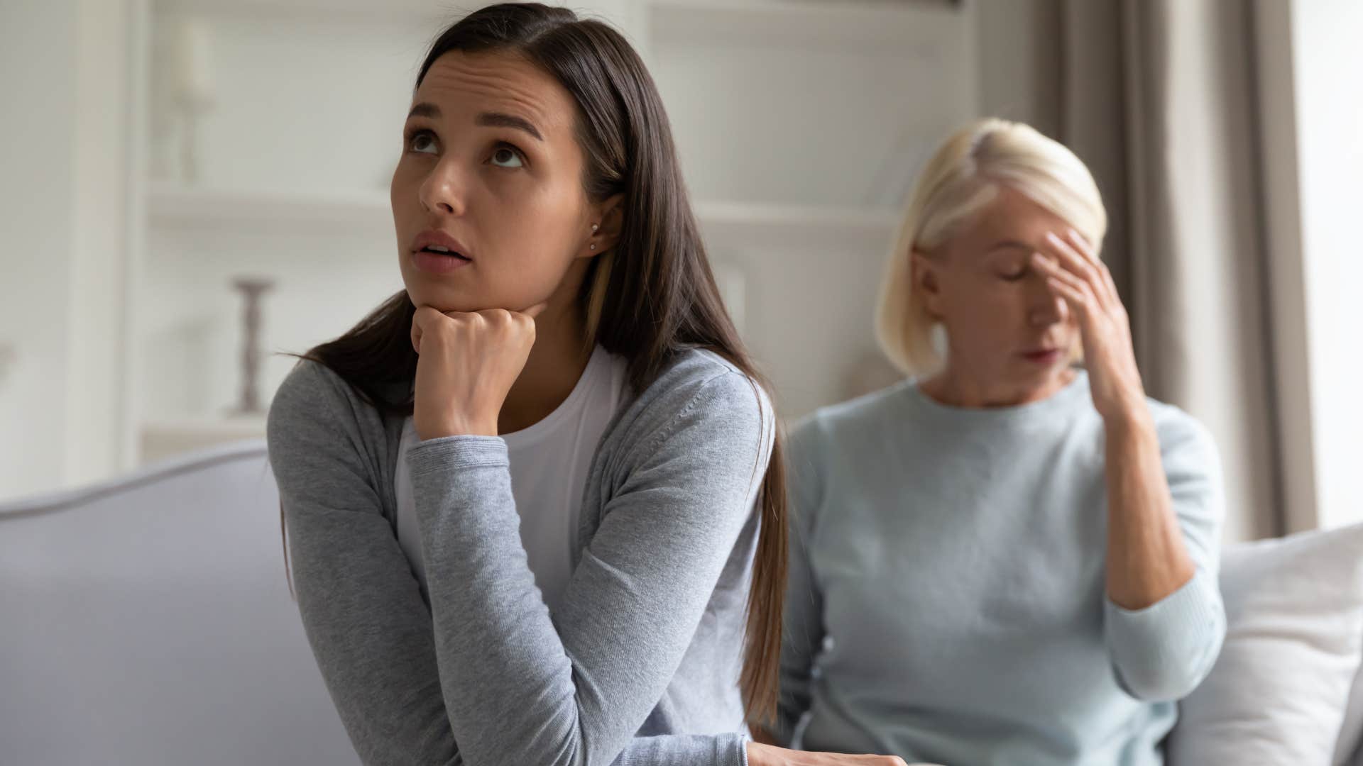 Adult daughter looking upset next to her mother.