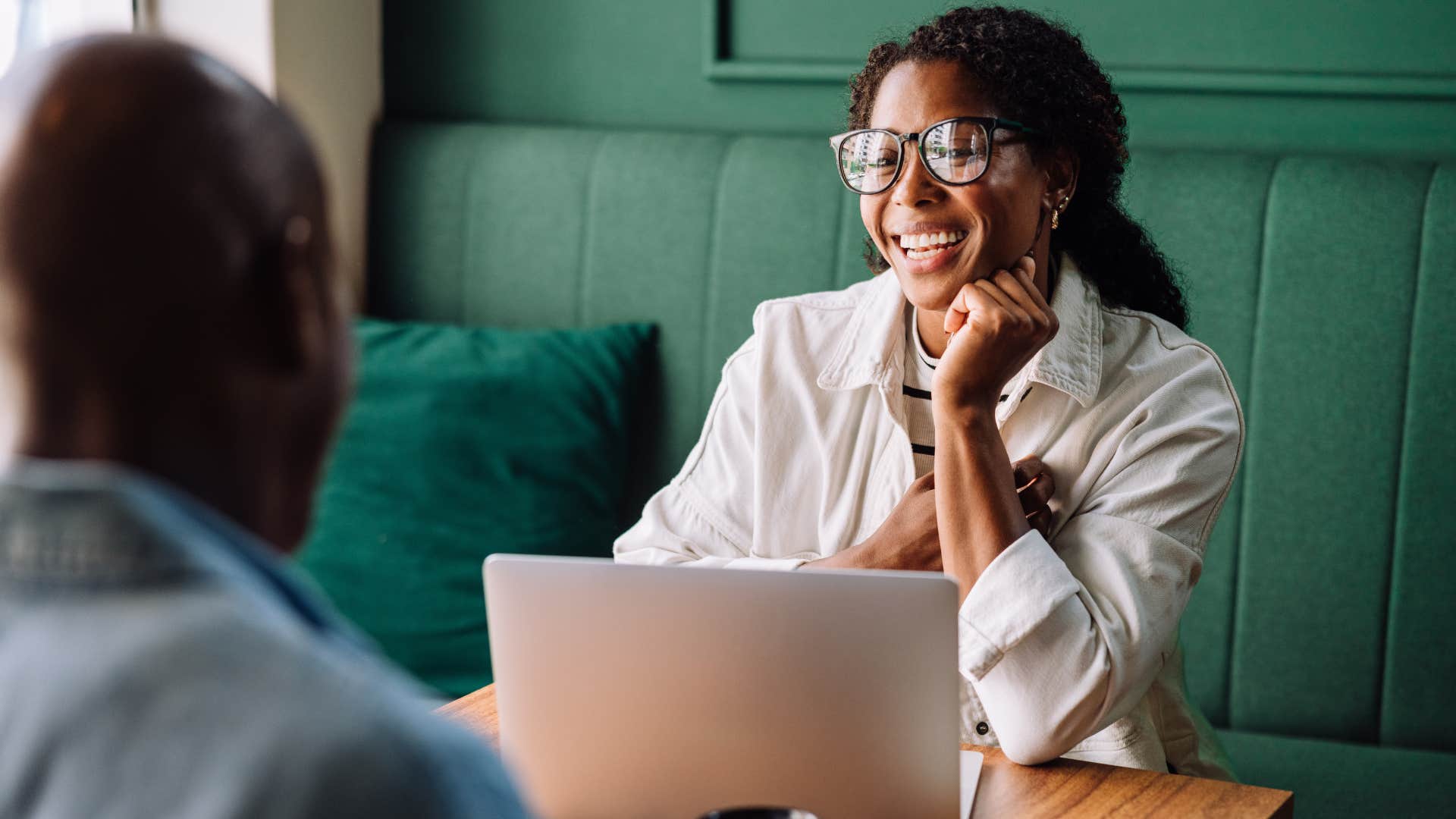 Woman smiling at a coffee shop across from a man