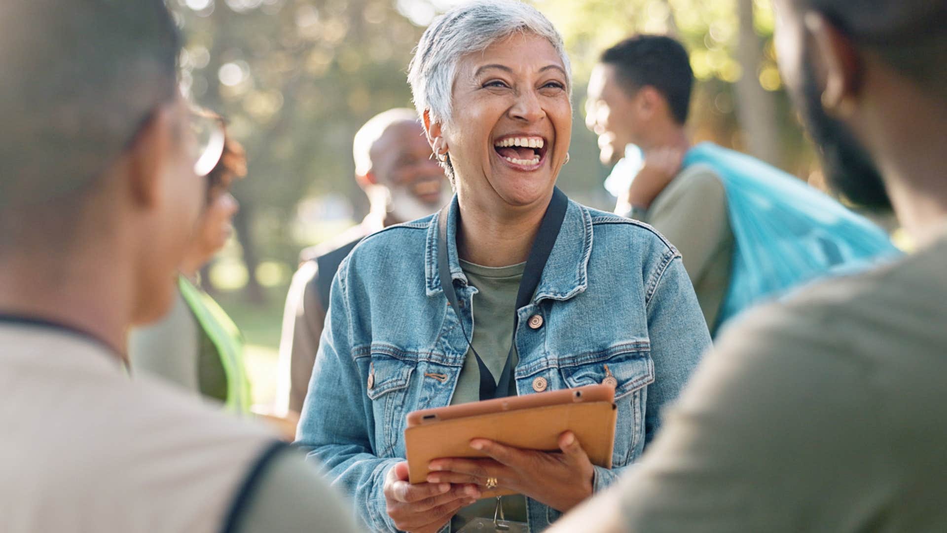 Older woman smiling while talking to two men