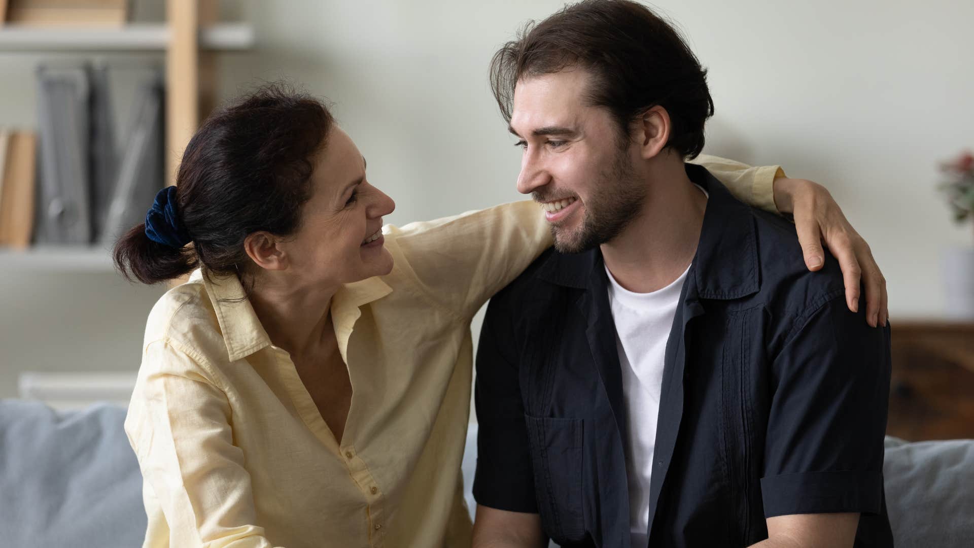 Adult son talking to his mother on the couch